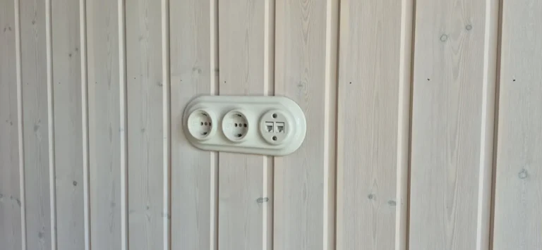 Kreminės keramikinės rozetės su interneto lizdu medinėje sienoje
